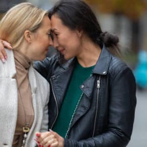 A Couple of Happy Multicultural Lesbians in Casual Clothes is Spending a Wonderful Day in the City and Feeling Cheerful While Has a Lovely Conversation and Emotional Embrace.
